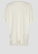 An off-white short-sleeve top shown from the back, featuring a sheer lace hem detail, photographed against a neutral light gray background.