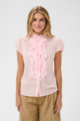 Woman wearing a light pink blouse with ruffles on a white background