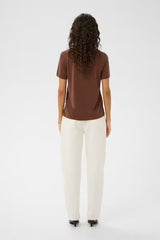 Person wearing a brown t-shirt and white pants on a white background