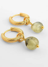 A pair of gold huggie hoop earrings with textured snake-like bands and dangling round olive-green beads, shown on a clean white background.