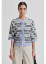 Woman wearing a striped cardigan with a plain background