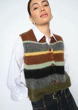 Person wearing a striped sweater vest over a white shirt on a plain background