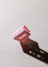 Pink textured cube on a light gray background