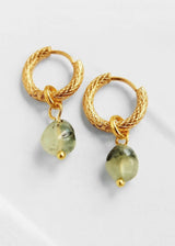 A pair of gold huggie hoop earrings with twisted rope details and dangling light green teardrop beads, shown on a clean white background.