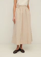 Person wearing a beige and white striped skirt on a plain background