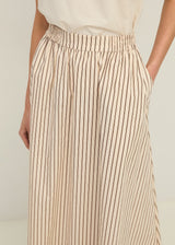 Beige and brown striped pants worn by a person on a plain background