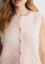 Light pink sleeveless top with button details on a plain background