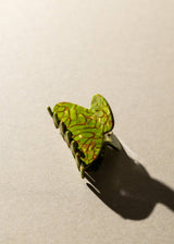 Green leaf-shaped object on a beige background