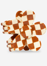 Checkered flower-shaped object on a light gray background