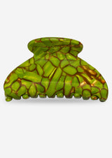 Green and gold patterned hair clip on a white background