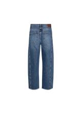 A pair of medium-wash blue denim jeans shown from the back, featuring a brown leather patch on the back waistband, photographed against a solid white background.