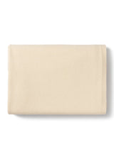 A folded cream-colored cotton blanket with a soft, textured surface, shown on a clean white background with a subtle drop shadow.