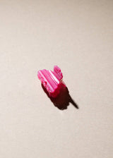 Pink hair clip on a beige surface